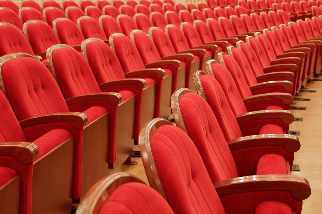 Rows of red upholstered seating inside Leeds Grand Theatre, one of the city's most iconic performance venues.