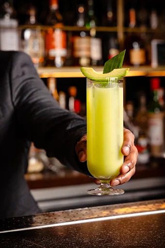 Bartender at Uyare Leeds serving a fresh Avocado cocktail made with Diplomatico rum and Bacardi.