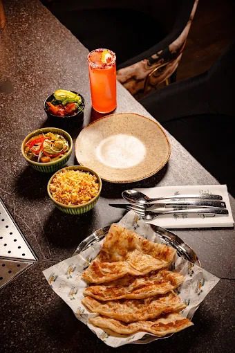 A chilli-rimmed Mango cocktail at Uyare rooftop bar in Leeds, served alongside Kerala-style sharing plates.