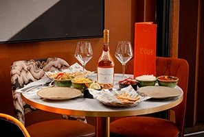 Restaurant table with wine, mezze dishes, and flatbread in cozy dining setting